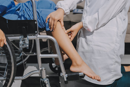 Physiotherapist checking knee of female patient stockの写真素材
