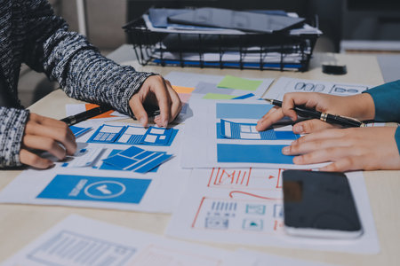Group of young application developers analyzing uxui mobile app templates during a working meetingの写真素材