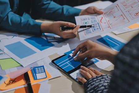 Group of young application developers analyzing uxui mobile app templates during a working meeting