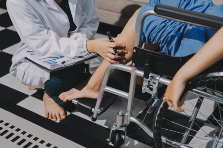 Physiotherapist checking knee of female patient stockの写真素材