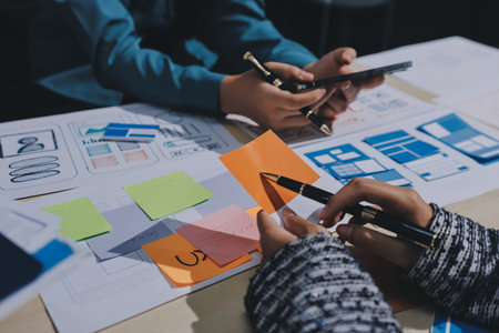 Group of young application developers analyzing uxui mobile app templates during a working meeting