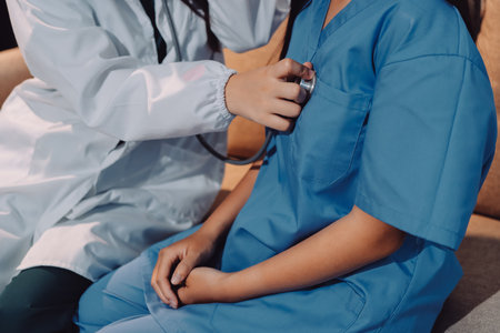 A doctor uses a stethoscope to check the heartbeat of his patient. Patients must undergo a yearly check-up for their health or a check-up from a cardiologist.の写真素材