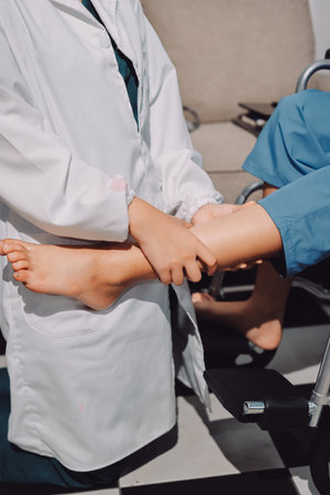 Physiotherapist checking knee of female patient stockの写真素材