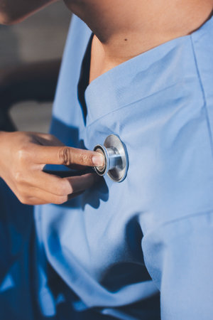 A physician uses a stethoscope to examine a patient's heart during a clinic appointment.