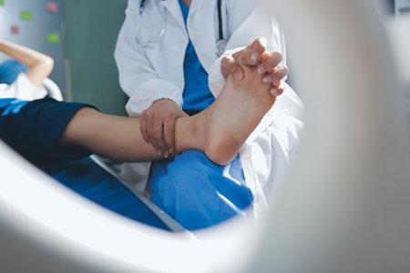 Female doctor hands doing physical therapy By extending the leg and knee of a male patientの写真素材