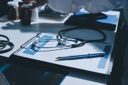 Cropped image of male doctor's hand using stethoscope to examining heartbeat and symptom of patient while talkingの写真素材