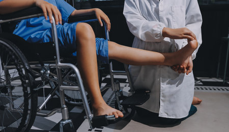 Physiotherapist checking knee of female patient stockの写真素材