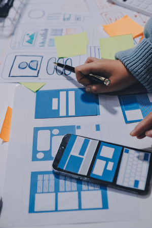 UX UI designer testing prototype on a phone, discussing and brainstorming on wireframes for a...