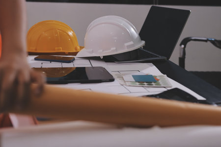 Closeup of team of industrial engineers meeting analyze machinery blueprints consult project on table in manufacturing factory. Working in manufacturing plant or production plant.の写真素材