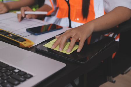 Closeup of team of industrial engineers meeting analyze machinery blueprints consult project on table in manufacturing factory. Working in manufacturing plant or production plant.の写真素材