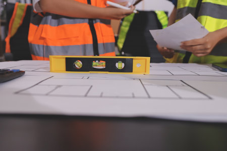 Closeup of team of industrial engineers meeting analyze machinery blueprints consult project on...