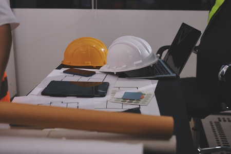 Closeup of team of industrial engineers meeting analyze machinery blueprints consult project on table in manufacturing factory. Working in manufacturing plant or production plant.の写真素材
