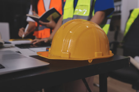 Closeup of team of industrial engineers meeting analyze machinery blueprints consult project on table in manufacturing factory. Working in manufacturing plant or production plant.の写真素材