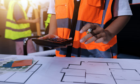 Closeup of team of industrial engineers meeting analyze machinery blueprints consult project on table in manufacturing factory. Working in manufacturing plant or production plant.の写真素材