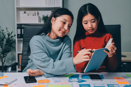 UX UI designer testing prototype on a phone, discussing and brainstorming on wireframes for a website and mobile app prototype, in the concept of website and mobile application design concept.の写真素材