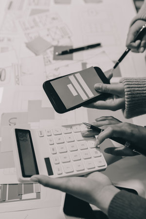 UX UI designer testing prototype on a phone, discussing and brainstorming on wireframes for a website and mobile app prototype, in the concept of website and mobile application design concept.の写真素材