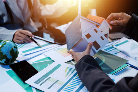 Asian woman lead young group of multiethnic businesspeople in team meeting, using laptop computer for ESG topic presentation on monitor. Sustainable business practice, people work at home conceptの写真素材
