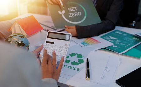 Asian woman lead young group of multiethnic businesspeople in team meeting, using laptop computer for ESG topic presentation on monitor. Sustainable business practice, people work at home conceptの写真素材