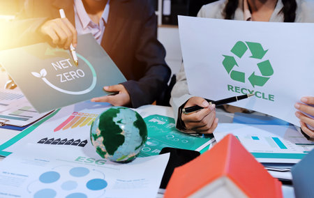 Asian woman lead young group of multiethnic businesspeople in team meeting, using laptop computer for ESG topic presentation on monitor. Sustainable business practice, people work at home conceptの写真素材