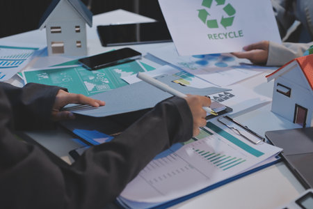 Asian woman lead young group of multiethnic businesspeople in team meeting, using laptop computer for ESG topic presentation on monitor. Sustainable business practice, people work at home conceptの写真素材