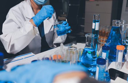 Scientist pipetting medical samples into microplate in laboratory