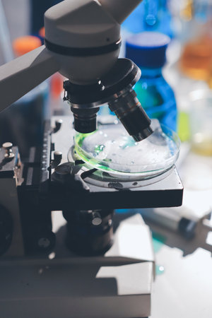 Scientist pipetting medical samples into microplate in laboratory