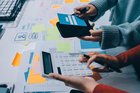 UX UI designer testing prototype on a phone, discussing and brainstorming on wireframes for a website and mobile app prototype, in the concept of website and mobile application design concept.の写真素材