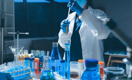 Scientist pipetting medical samples into microplate in laboratory