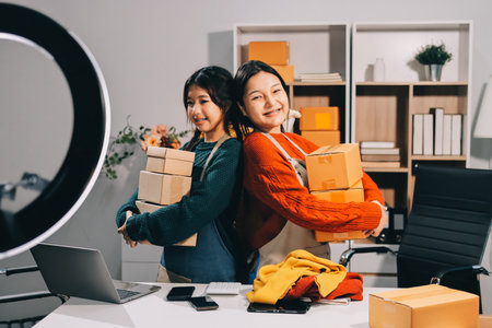 Portrait of Starting small businesses SME owners, two Asian woman check online orders Selling products working with boxs freelance work at home office, sme business online small medium enterpriseの写真素材