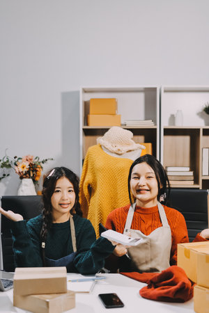 Portrait of Starting small businesses SME owners, two Asian woman check online orders Selling products working with boxs freelance work at home office, sme business online small medium enterpriseの写真素材