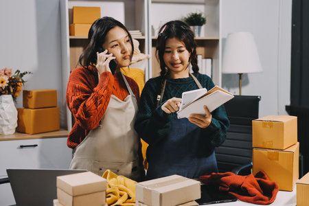 Portrait of Starting small businesses SME owners, two Asian woman check online orders Selling products working with boxs freelance work at home office, sme business online small medium enterpriseの写真素材