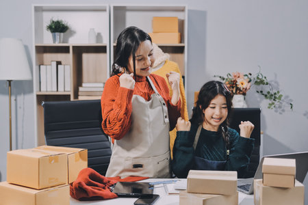 Portrait of Starting small businesses SME owners, two Asian woman check online orders Selling products working with boxs freelance work at home office, sme business online small medium enterpriseの写真素材