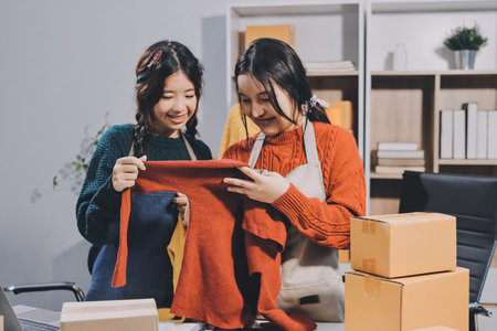 Portrait of Starting small businesses SME owners, two Asian woman check online orders Selling products working with boxs freelance work at home office, sme business online small medium enterpriseの写真素材