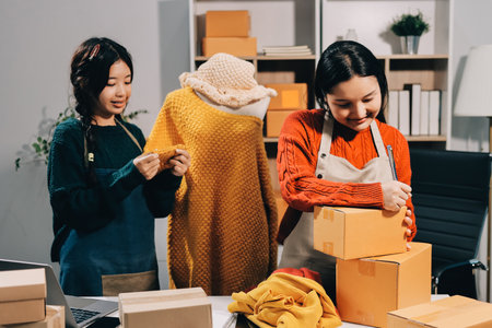 Portrait of Starting small businesses SME owners, two Asian woman check online orders Selling...