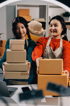 Portrait of Starting small businesses SME owners, two Asian woman check online orders Selling...