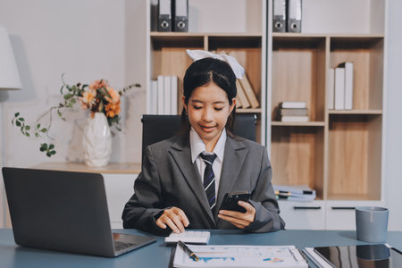 Portrait of a happy Asian businesswoman using mobile phone indoor, Asian businesswoman working in...
