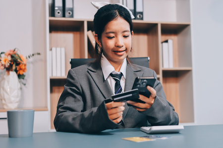 Close up woman hand using credit card and smartphone laptop for buying online shoppingの写真素材