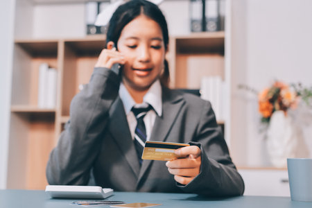 Close up woman hand using credit card and smartphone laptop for buying online shoppingの写真素材