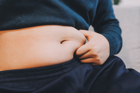 woman's hand holding excessive belly fat, overweight conceptの写真素材