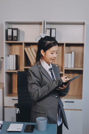 Portrait of Young Asian woman hand freelancer is working her job on computer tablet in modern...