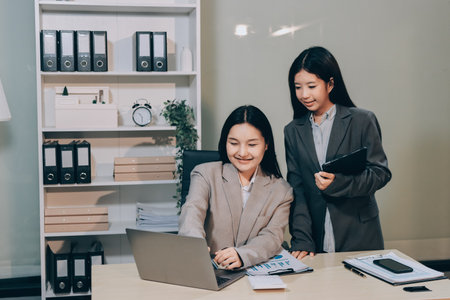 Entrepreneur Asian businessman and businesswoman discussing new business project in tablet in modern Meeting In Modern Office, Asian business casual concept.の写真素材