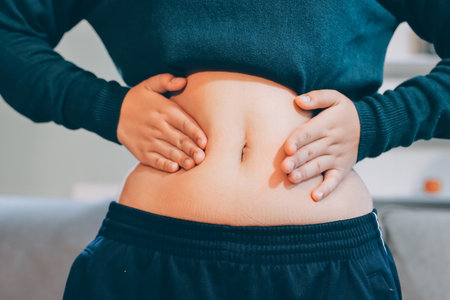 woman's hand holding excessive belly fat, overweight conceptの写真素材