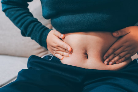 woman's hand holding excessive belly fat, overweight concept