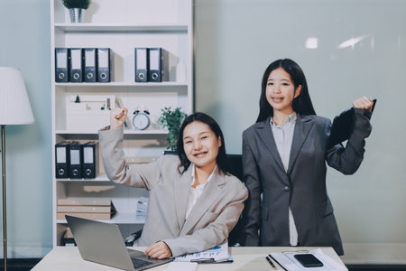Entrepreneur Asian businessman and businesswoman discussing new business project in tablet in modern...