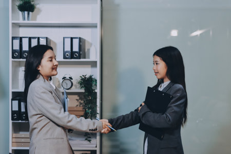Entrepreneur Asian businessman and businesswoman discussing new business project in tablet in modern Meeting In Modern Office, Asian business casual concept.の写真素材