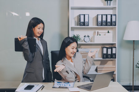 Entrepreneur Asian businessman and businesswoman discussing new business project in tablet in modern Meeting In Modern Office, Asian business casual concept.の写真素材