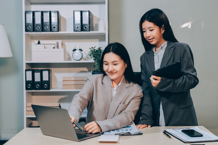 Entrepreneur Asian businessman and businesswoman discussing new business project in tablet in modern Meeting In Modern Office, Asian business casual concept.の写真素材