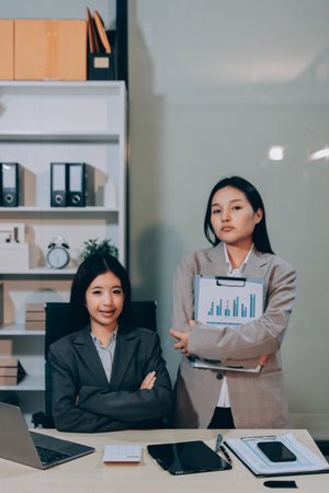 Entrepreneur Asian businessman and businesswoman discussing new business project in tablet in modern Meeting In Modern Office, Asian business casual concept.の写真素材