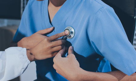 A physician uses a stethoscope to examine a patient's heart during a clinic appointment.