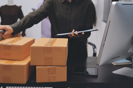 Portrait of Starting small businesses SME owners, two Asian woman check online orders Selling products working with boxs freelance work at home office, sme business online small medium enterpriseの写真素材